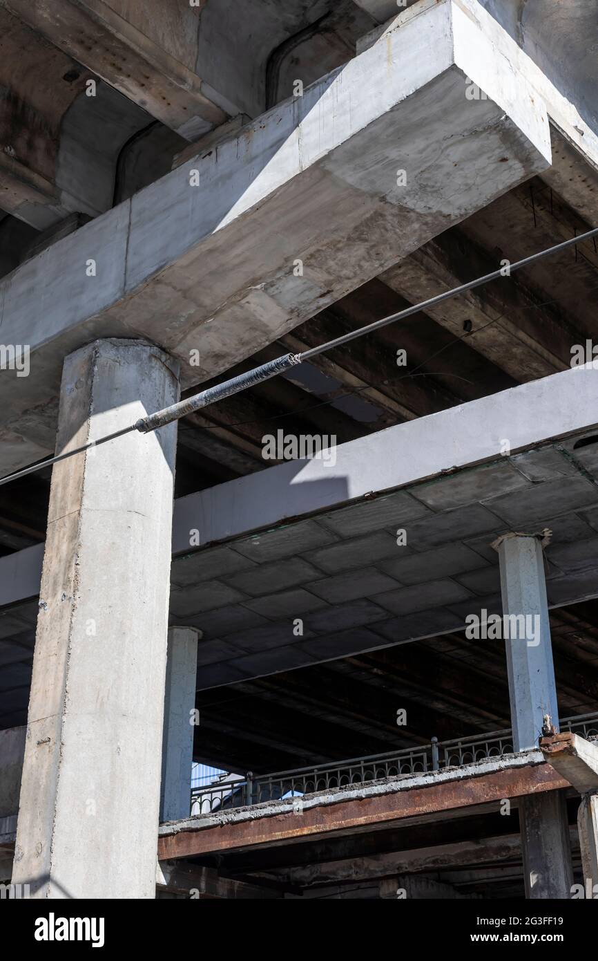 Struttura in cemento armato del cavalcavia autostradale. Incrinatura di travi in calcestruzzo sotto il ponte. Vista dal basso verso il basso. Foto Stock