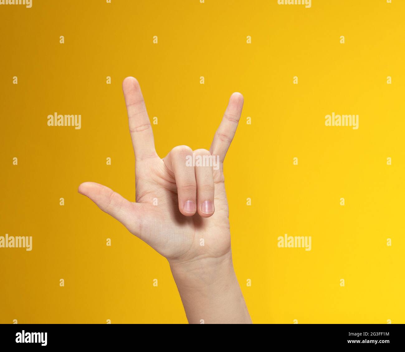 Mano con tre dita sollevate su sfondo giallo. Simbolo che significa in lingua americana dei segni frase i Love You Foto Stock