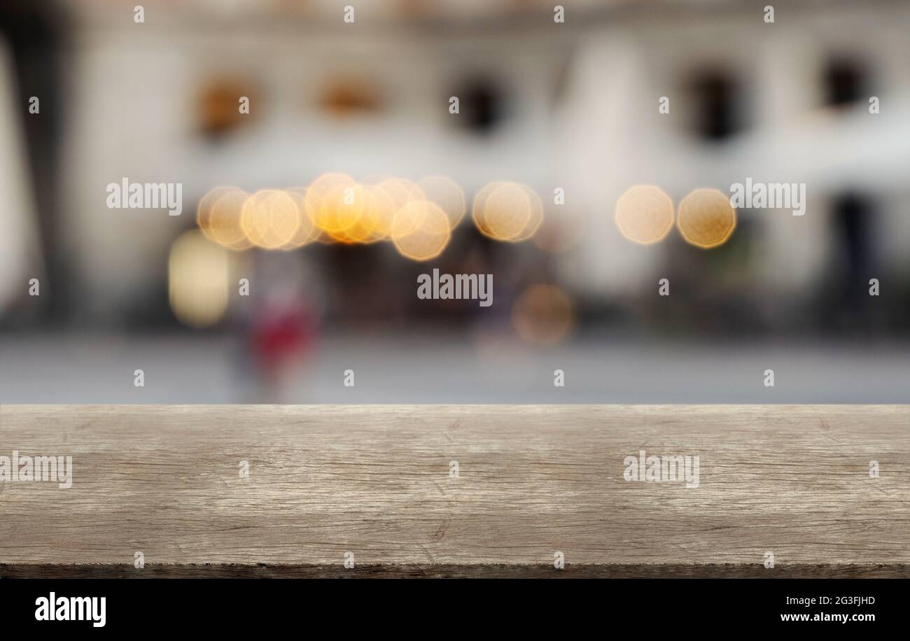 Tavolo rustico in legno su terrazza offuscata astratta sfondo quadrato. Montaggio, esposizione prodotti. Foto Stock