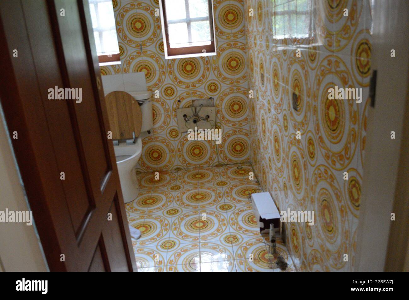 Uno dei bagni della casa era coperto da pavimento a soffitto in piastrelle gialle luminose. VIRGINIA WATER, Regno Unito: ENTRA nella spettacolare ex casa di Foto Stock