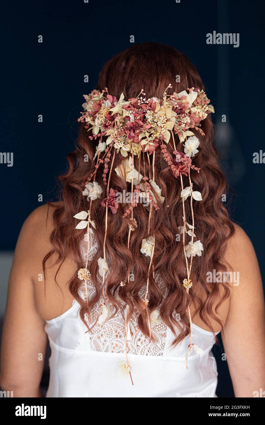 Vista posteriore della pettinatura boho di una sposa, testa floreale, messa a fuoco morbida Foto Stock