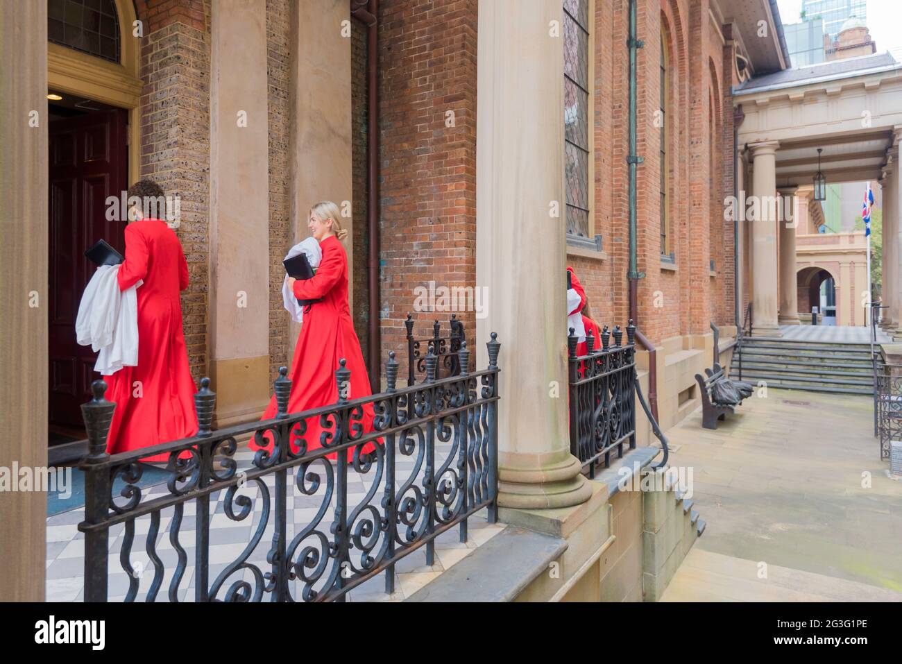 I coristi rossi entravano nella chiesa di St James (King Street) nel centro di Sydney la domenica mattina in Australia Foto Stock