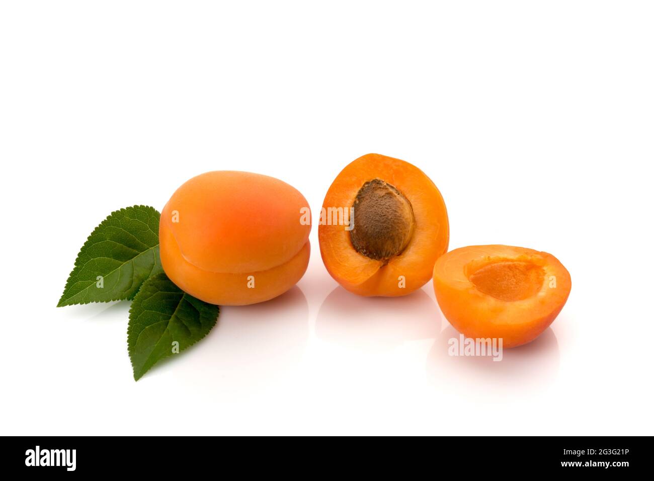 Albicocca intera con foglie e una tagliata a metà con il seme, isolata su bianco Foto Stock