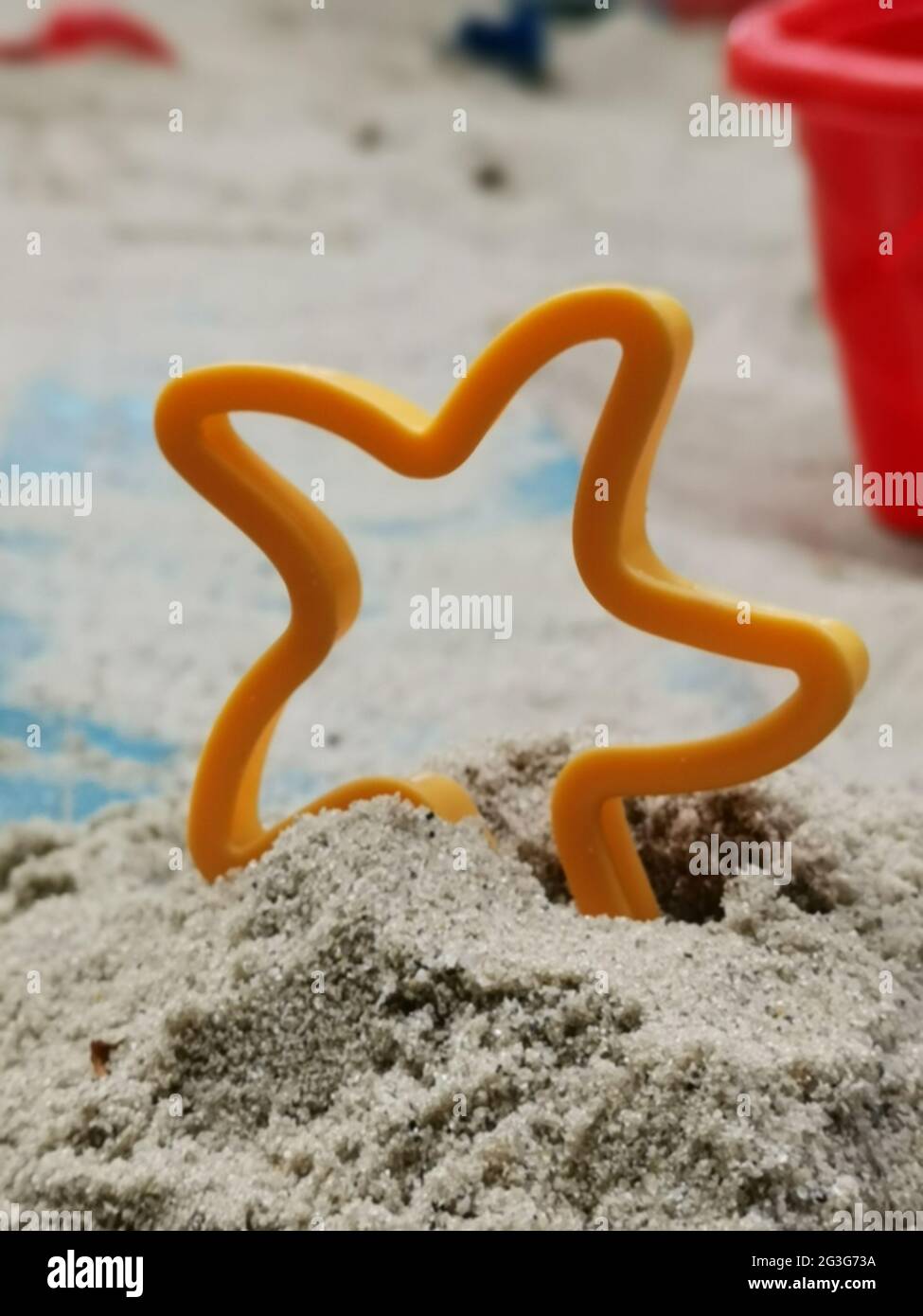 Tiro verticale di una stella giocattolo piantata nella sabbia all'aperto Foto Stock