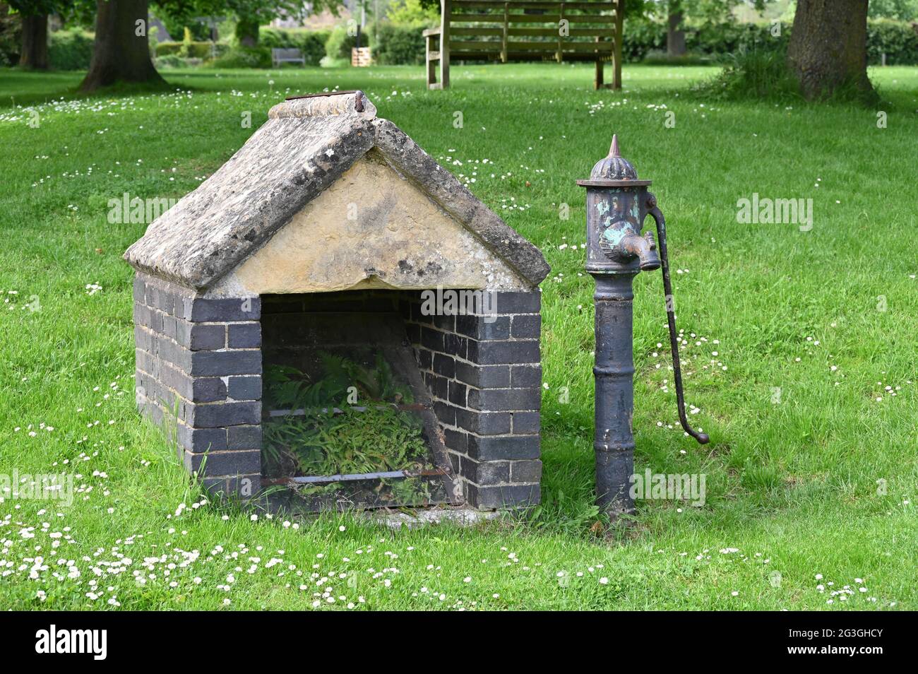 Ex pompa d'acqua sul verde nel nord Oxfordshire villaggio di Kingham Foto Stock