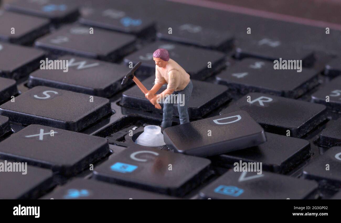 Lavoratore in miniatura con pickaxe che lavora sulla tastiera Foto Stock