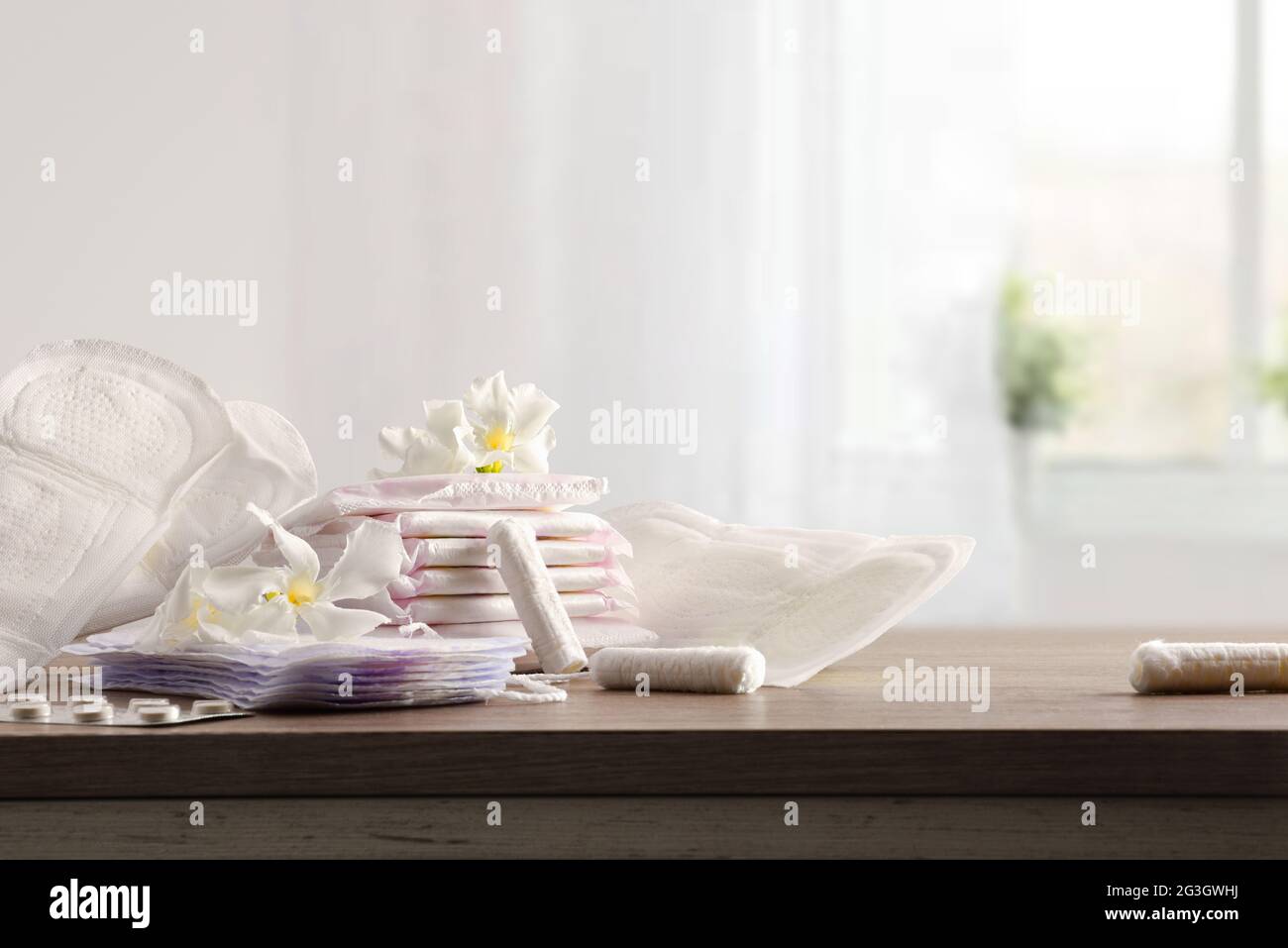 Prodotti per l'igiene mestruale e protezione per le donne su tavolo di legno in camera. Vista frontale. Foto Stock