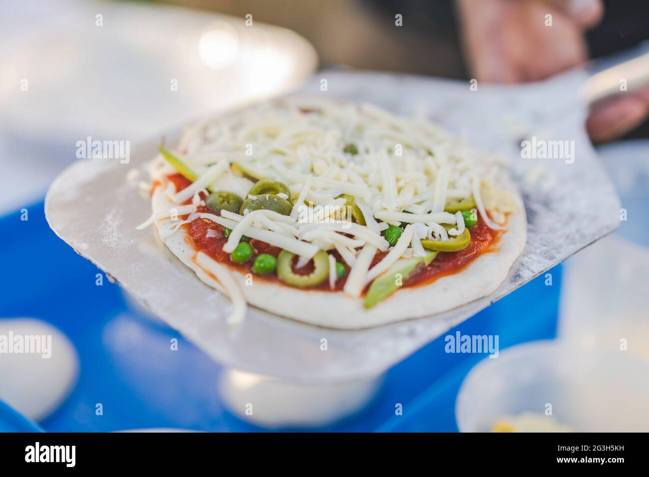 Preparare la pizza fatta in casa prima di cuocere la pasta per pizza con cibo tradizionale italiano con verdure e formaggio Foto Stock