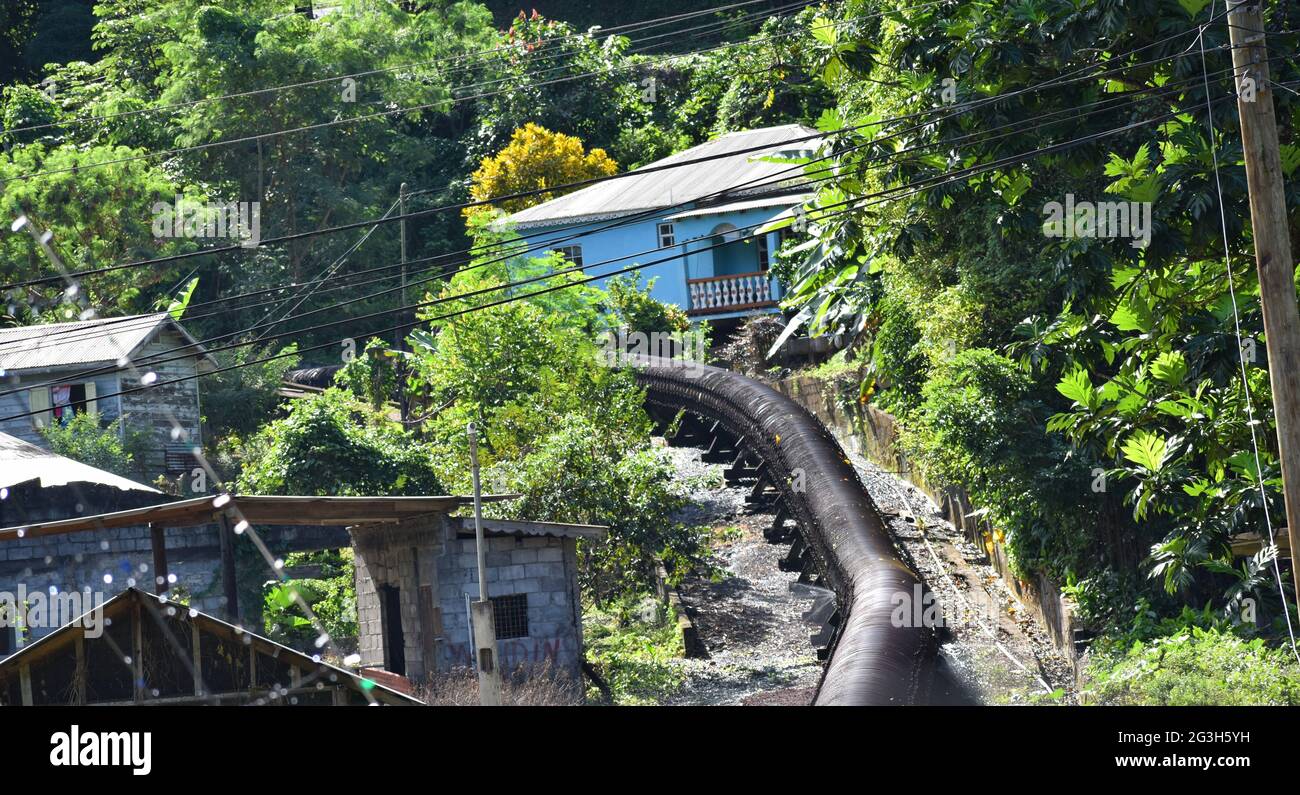 Linea d'acqua di legno che attraversa una comunità a Saint Vincent e Grenadine. Foto Stock
