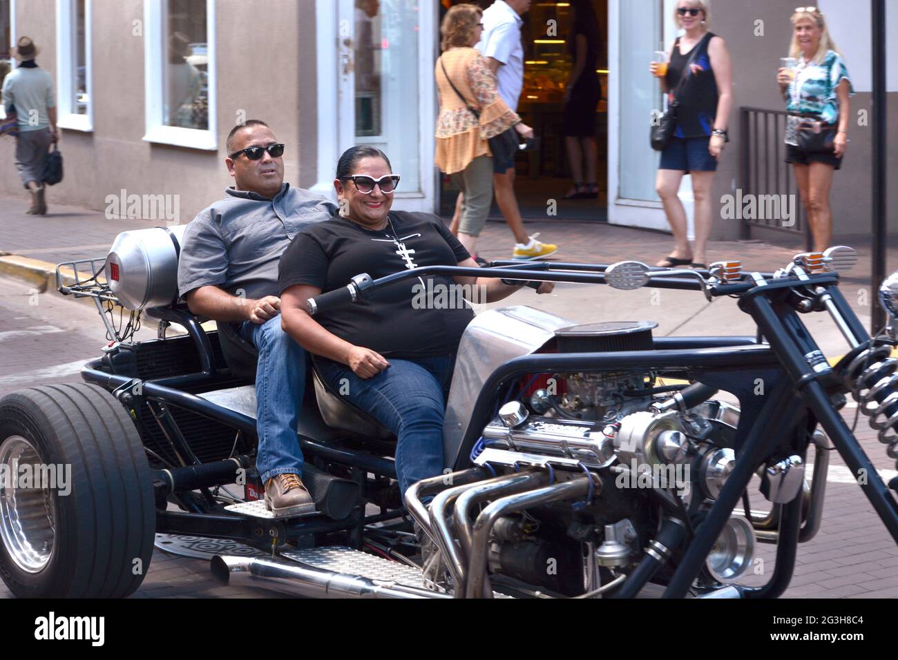 Una coppia ispanica attraversa Santa Fe, New Mexico, nella loro moto a tre ruote personalizzata in casa, conosciuta come un trike. Foto Stock