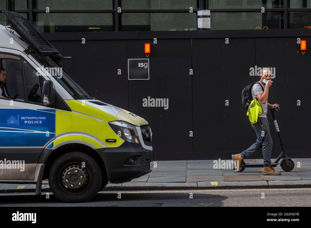 Londra, Regno Unito. 16 Giugno 2021. Un uomo cammina il suo scooter illegale davanti a un pulmino di polizia e 50 metri più avanti lungo la strada che si torna su di esso. Gli scooters elettrici illegali sono generalmente ancora ignorati dalla polizia. Credit: Guy Bell/Alamy Live News Foto Stock