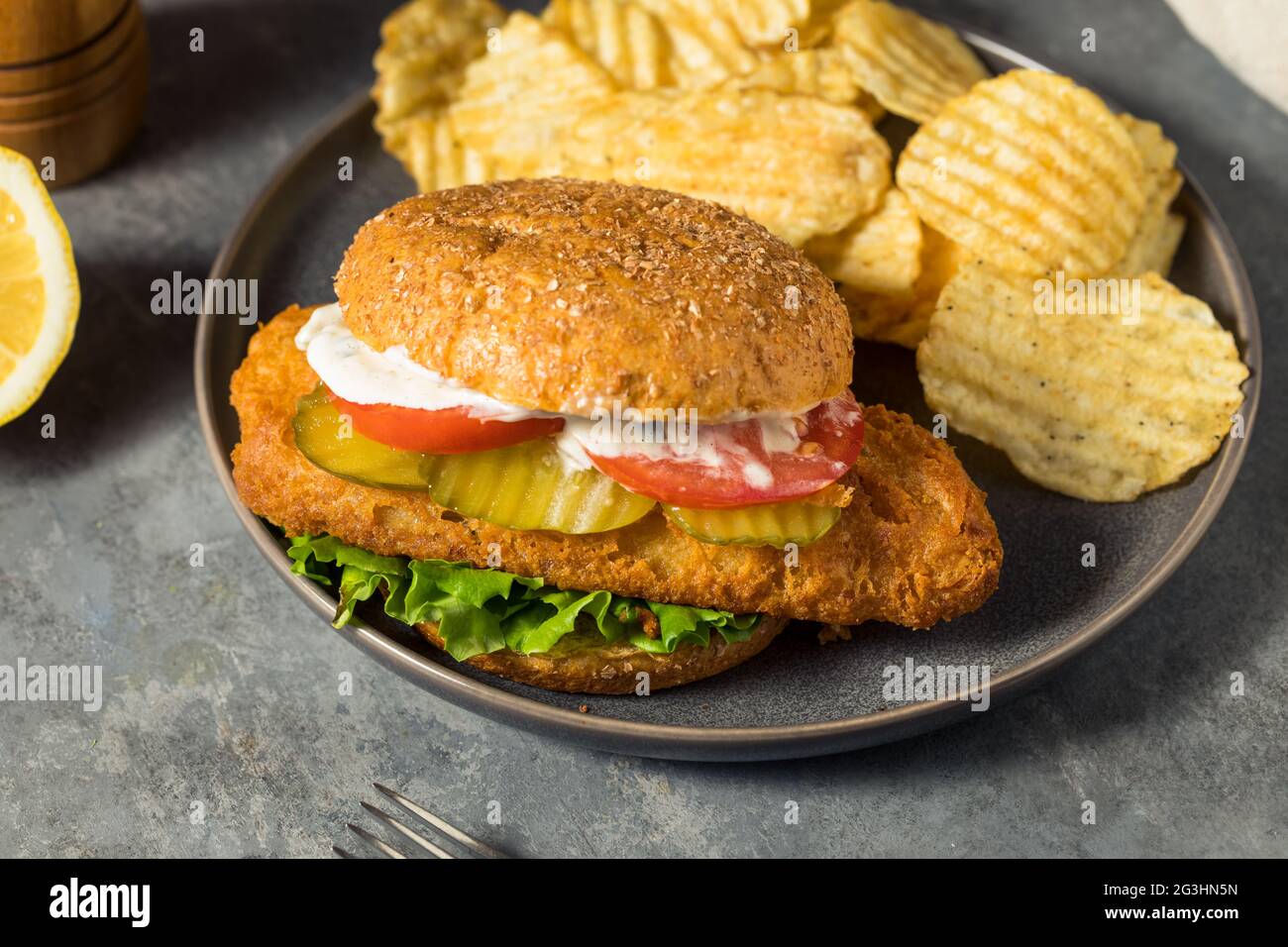 Panino di filetto di pesce fritto e croccante fatto in casa con patatine Foto Stock