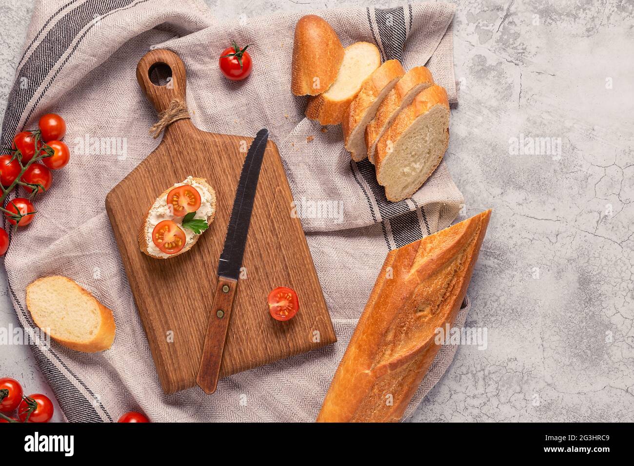 tavola, pane e pomodori per preparare i sandwich Foto Stock