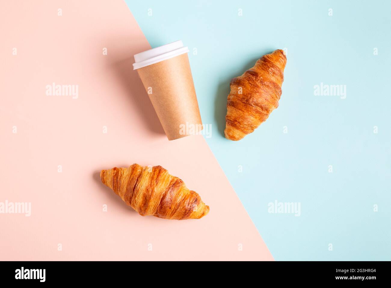Caffè da gustare in una tazza di carta con croissant, vista dall'alto. Foto Stock