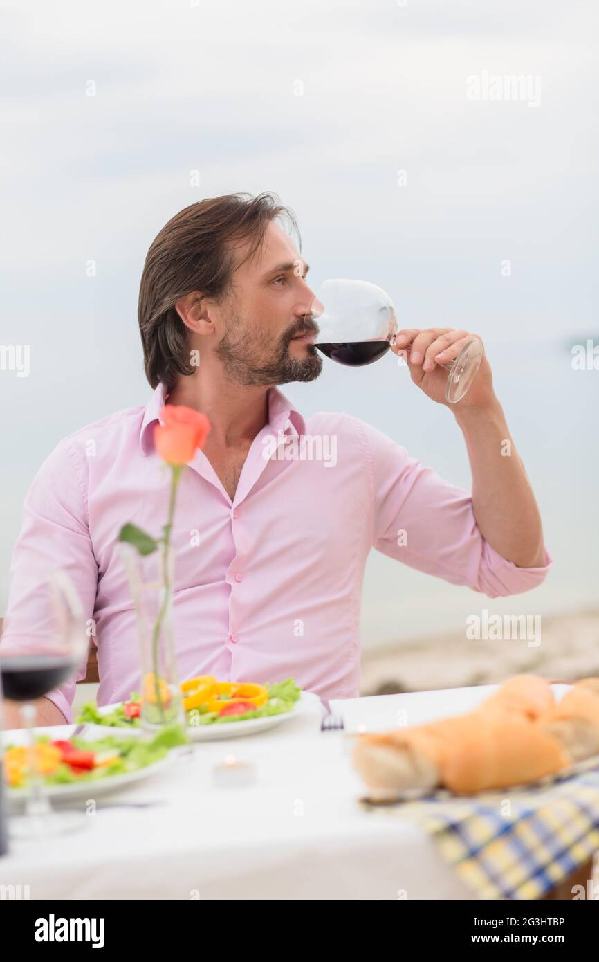 Uomo bello bere un vino Foto Stock