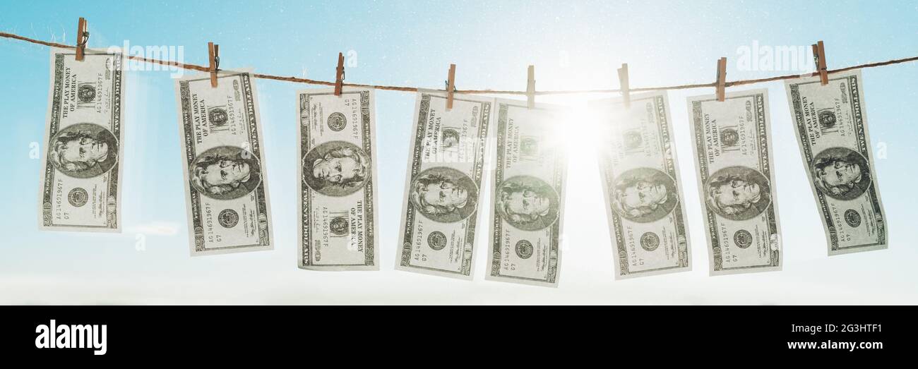 Banner sul concetto di riciclaggio di denaro. Panoramica di US dollards appesi ad asciugare per lavanderia su stendibiancheria. Foto Stock