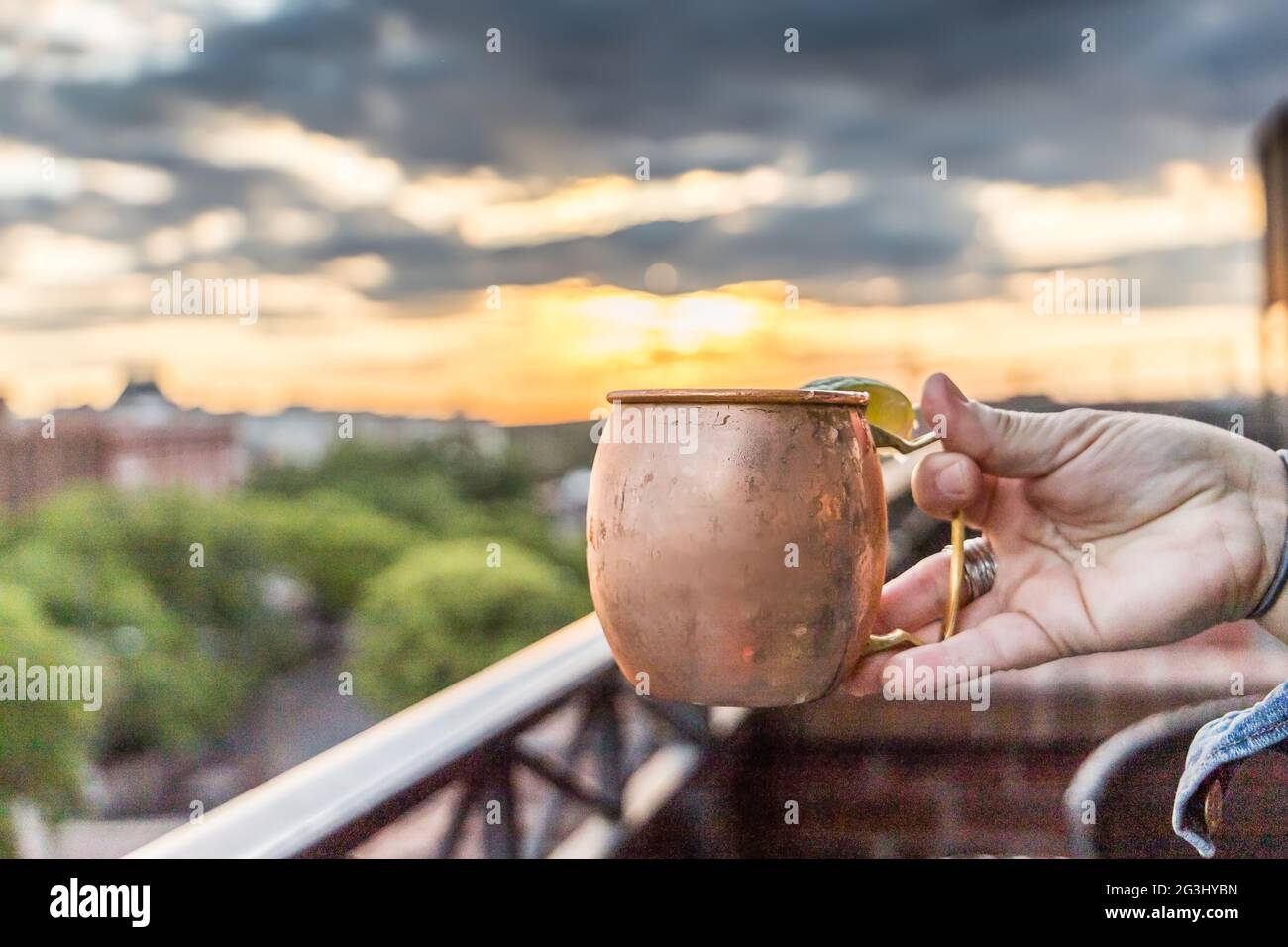 Un mule di mosca tenuto in su ad un bar ristorante sul tetto al tramonto Foto Stock