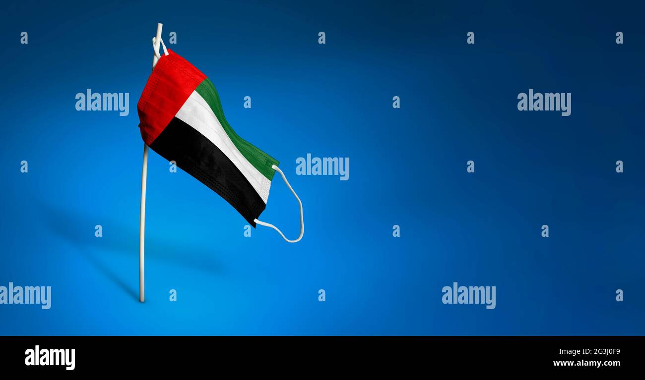 Bandiera ondulata degli Emirati Arabi Uniti dipinta su maschera medica sul palo. Concetto del banner della lotta contro l'epidemia coronavirus COVID-19. Foto Stock