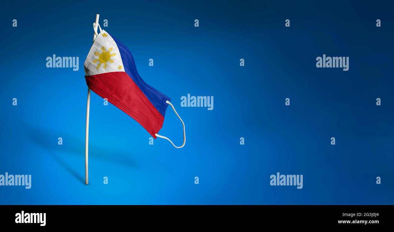 Bandiera ondulata delle Filippine dipinta su maschera medica sul palo. Concetto del banner della lotta contro l'epidemia coronavirus COVID-19. Copia spa Foto Stock