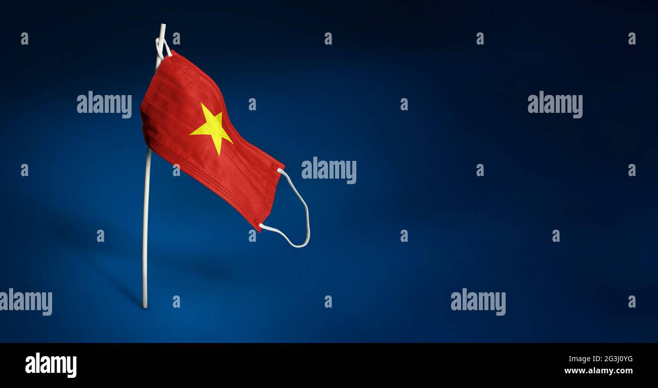 Bandiera ondulata del Vietnam dipinta su maschera medica sul palo. Concetto del banner della lotta contro l'epidemia coronavirus COVID-19. Spazio di copia Foto Stock
