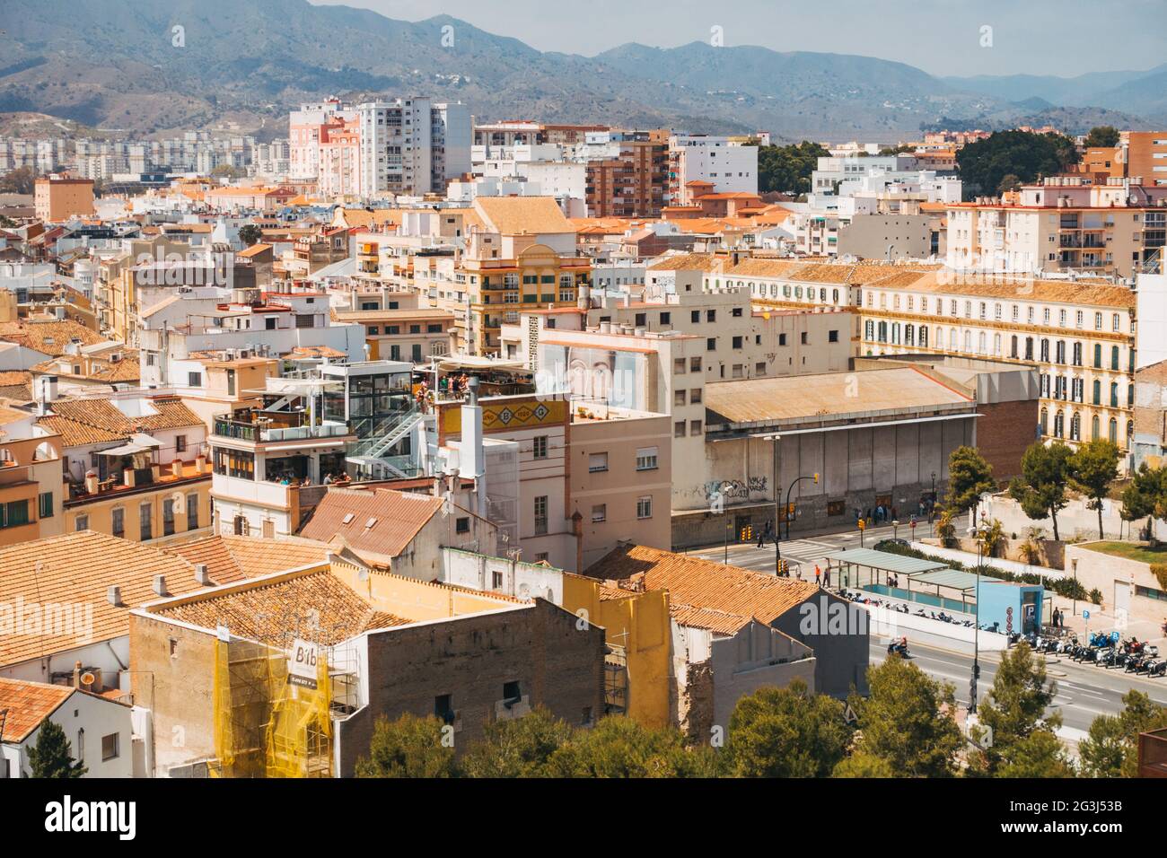 Sbircia attraverso le varie sfumature pastello di bianco, giallo e terracotta della città di Málaga, Spagna Foto Stock