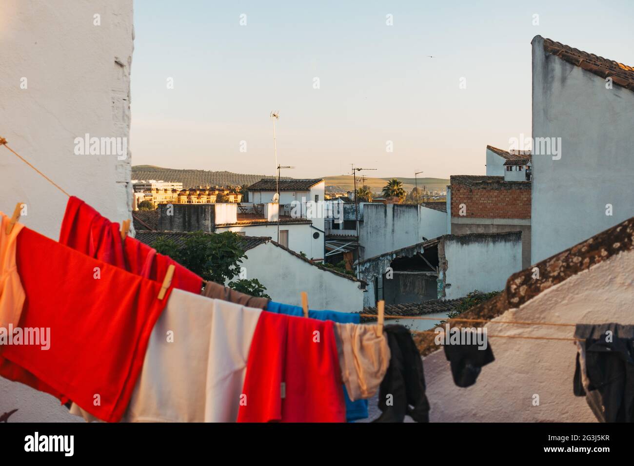 Si affaccia sui tetti delle case di Córdoba, in Spagna, in una serata limpida. Alcuni lavaggi si asciugano in primo piano Foto Stock