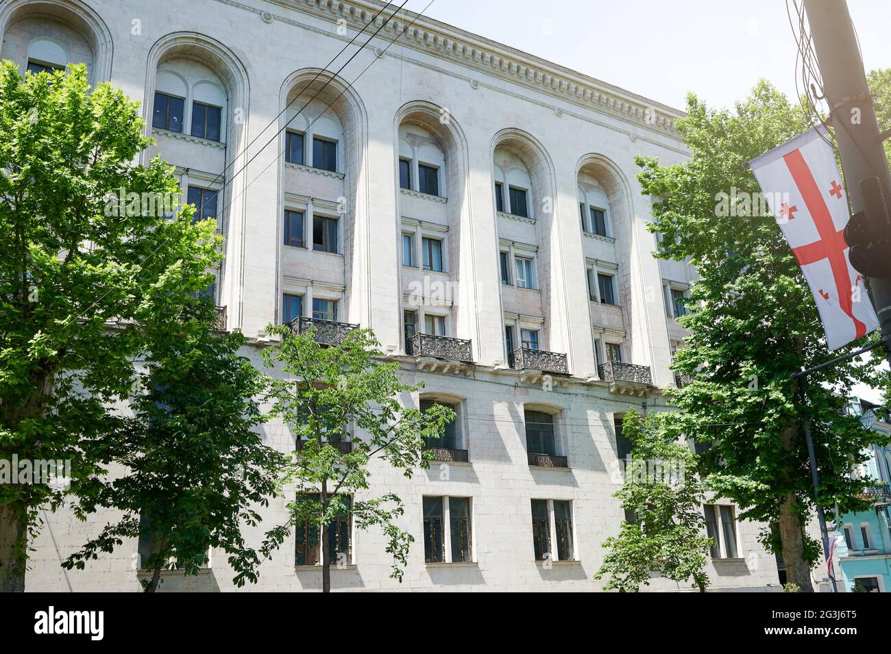 Bandiera della Georgia sullo sfondo dell'edificio in un giorno di sole luminoso Foto Stock