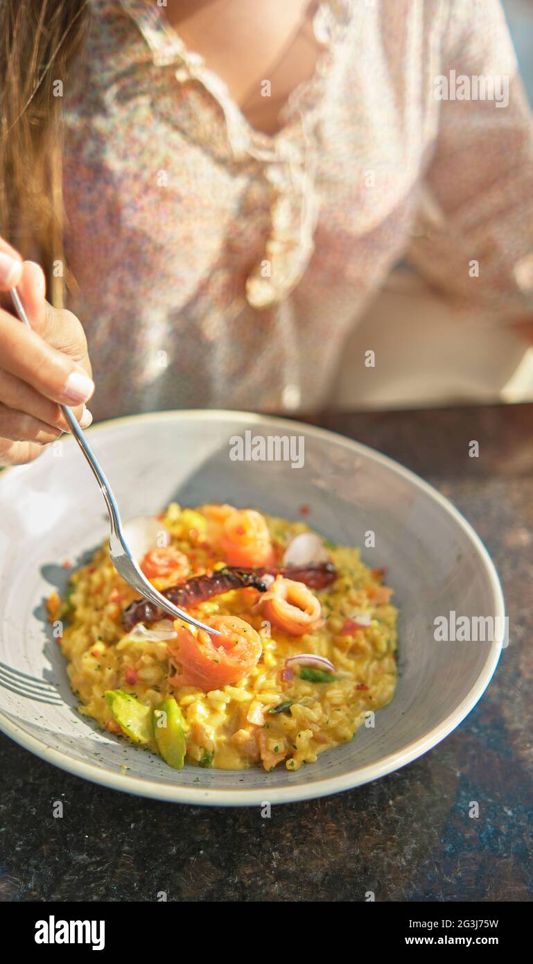 Bella giovane ragazza che assaggia un delizioso risotto con salmone  affumicato Foto stock - Alamy