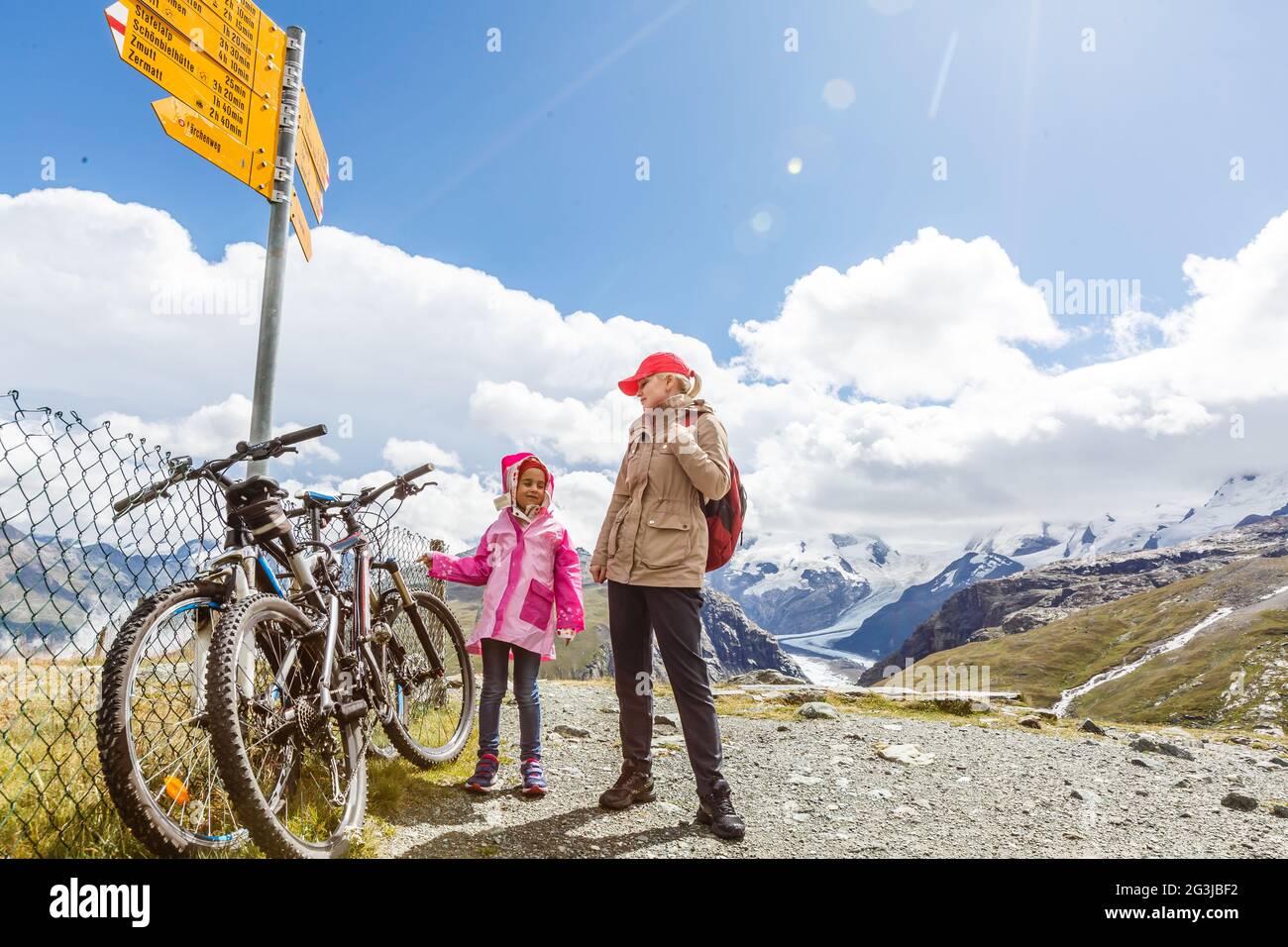 madre e figlia con zaino seduto sul sentiero in montagna al giorno. Foto Stock