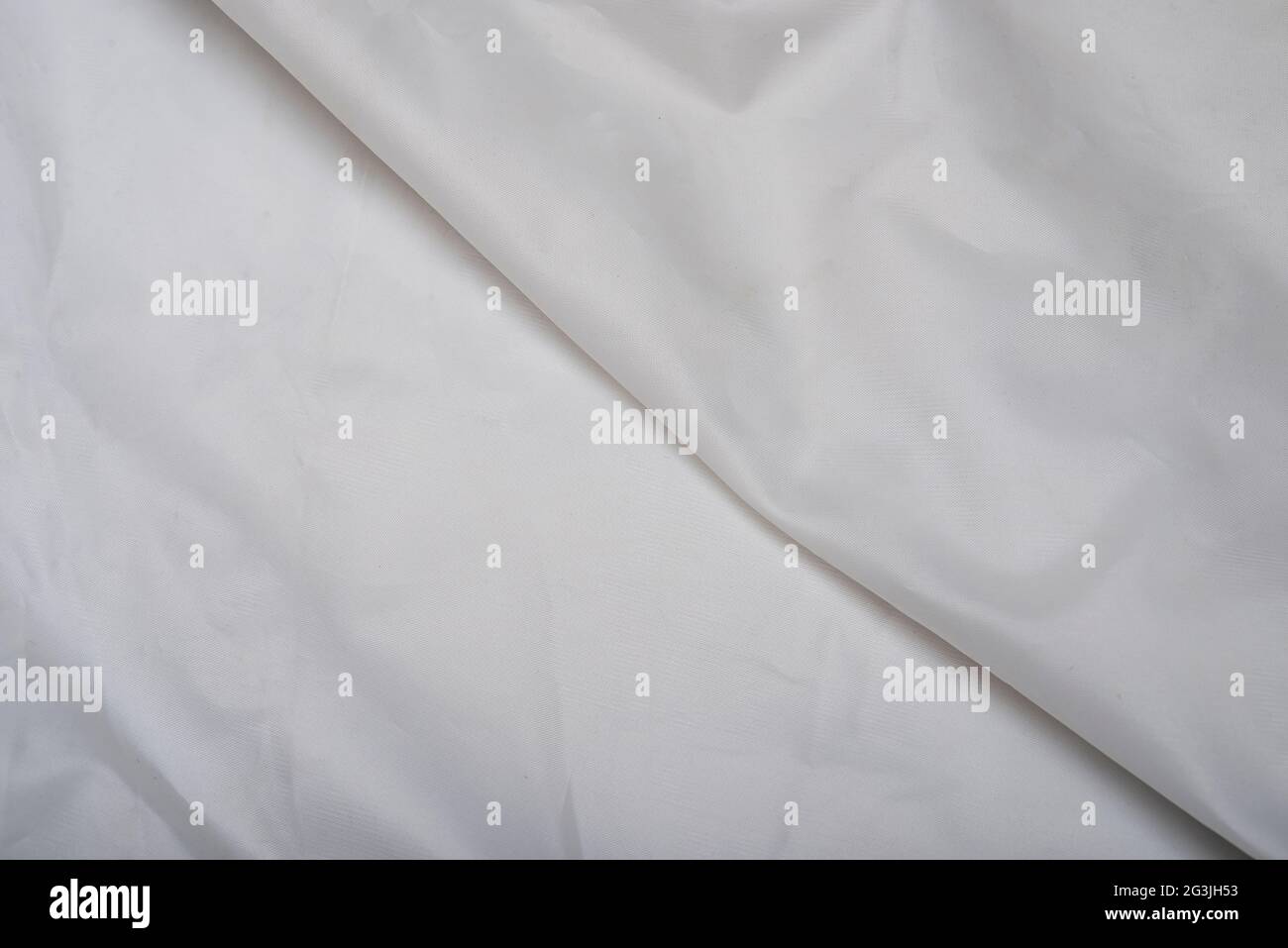 Tessuto bianco setoso che fa sfondo con una linea al centro. Foto Stock