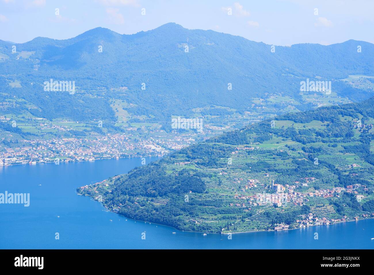 Vista aerea del lago d'Iseo, montagne boscose, vari villaggi sparsi lungo le pendici delle montagne e lungo la costa. Lago d'Iseo in provincia di Brescia Foto Stock