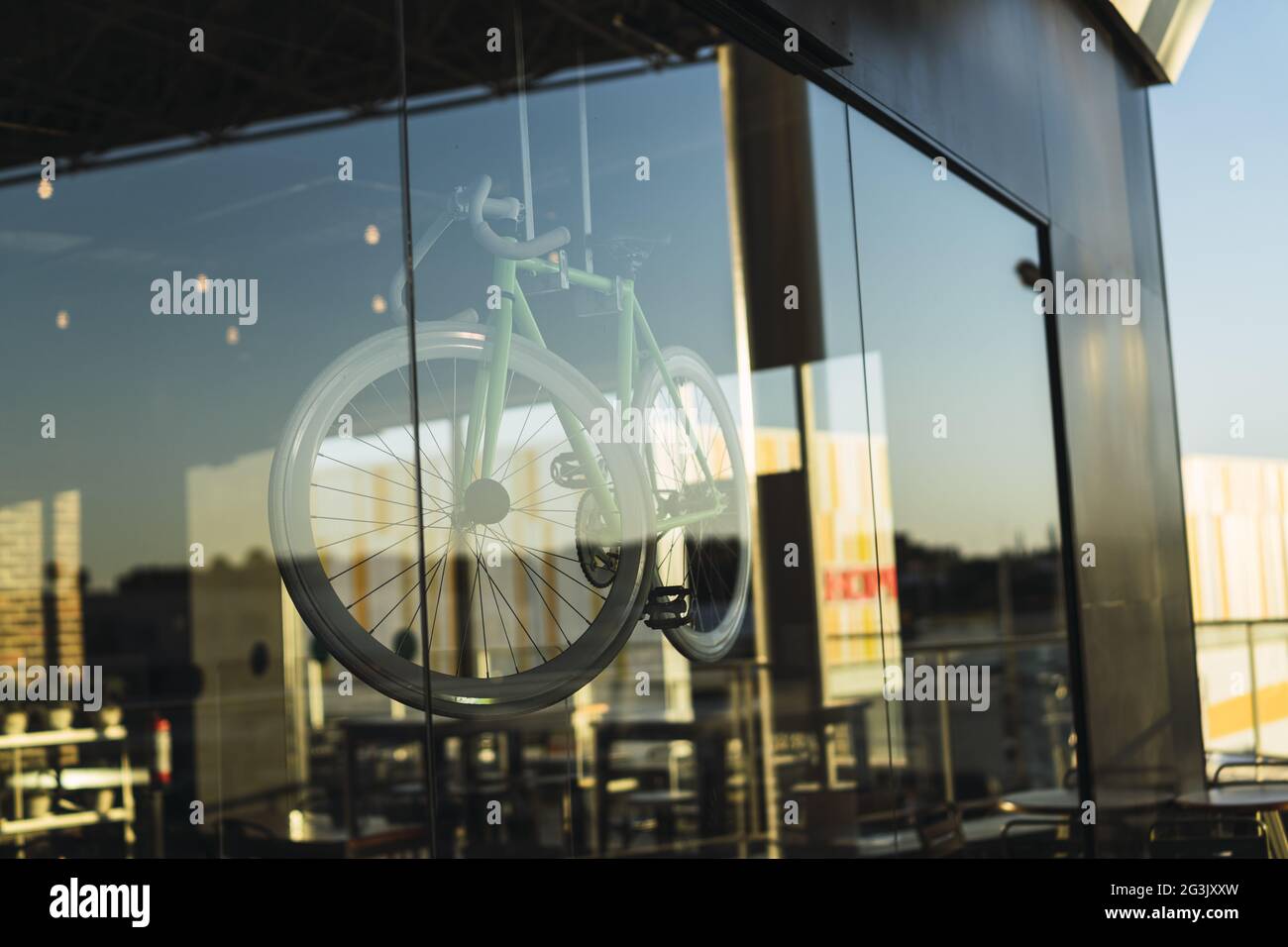 Primo piano di una bicicletta esposta come vista attraverso una parete di vetro di un edificio commerciale Foto Stock