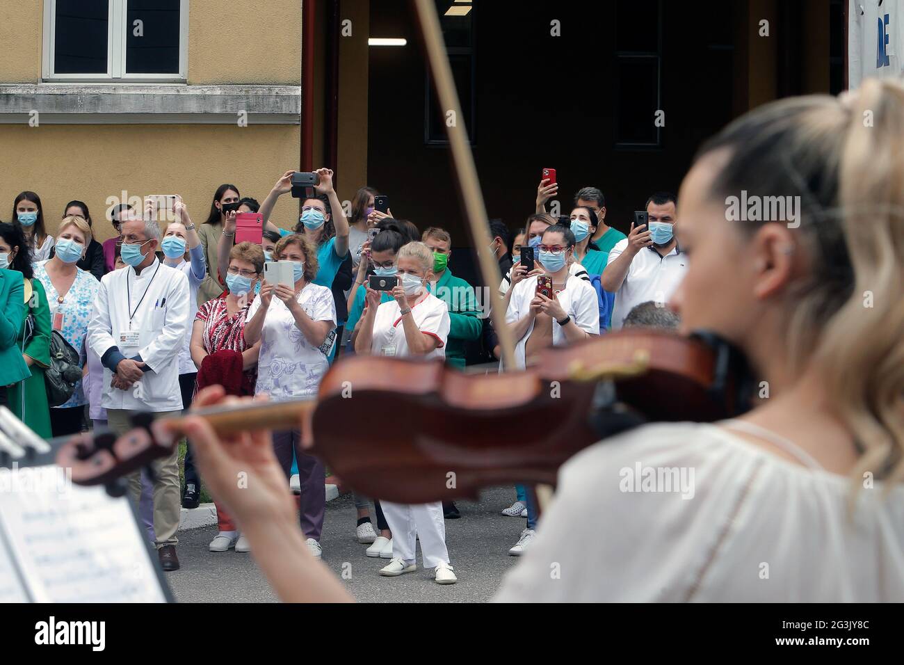 Bucarest, Romania. 16 Giugno 2021. Gli operatori sanitari guardano la performance di una band musicale classica a Bucarest, Romania, il 16 giugno 2021. La band si è esibita per ringraziare gli operatori sanitari che hanno combattuto la pandemia COVID-19 a Bucarest mercoledì. Credit: Cristian Cristel/Xinhua/Alamy Live News Foto Stock