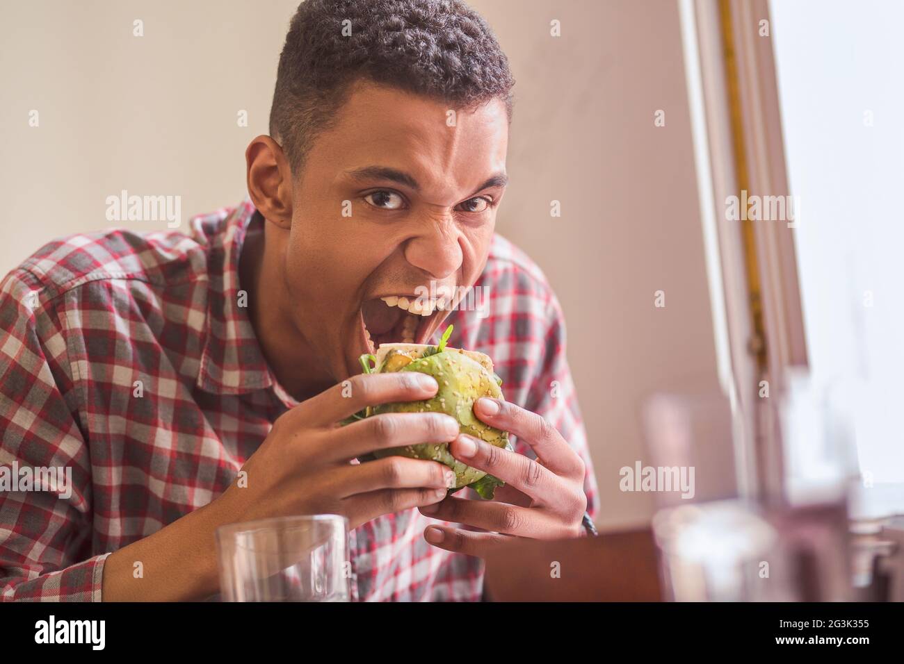 L'uomo mangiare vegan burger in ristorante Foto Stock