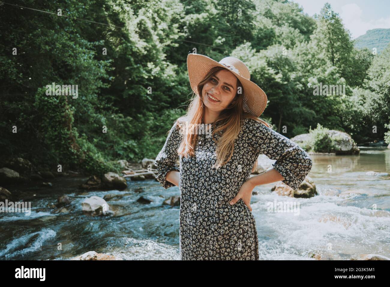 bella donna bionda con cappello dal fiume in natura Foto Stock