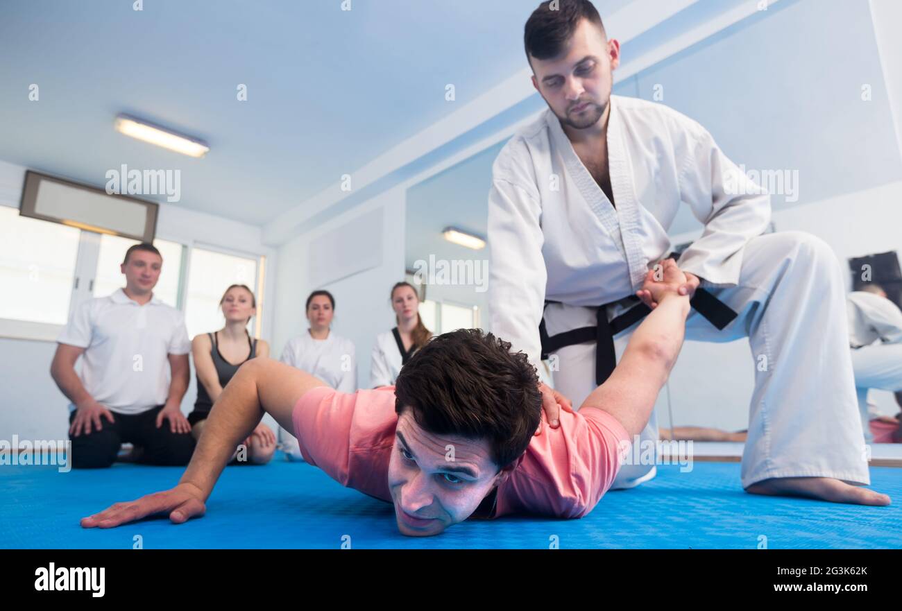 uomo formazione nuovo taekwondo tiene con gli adulti durante la classe Foto Stock