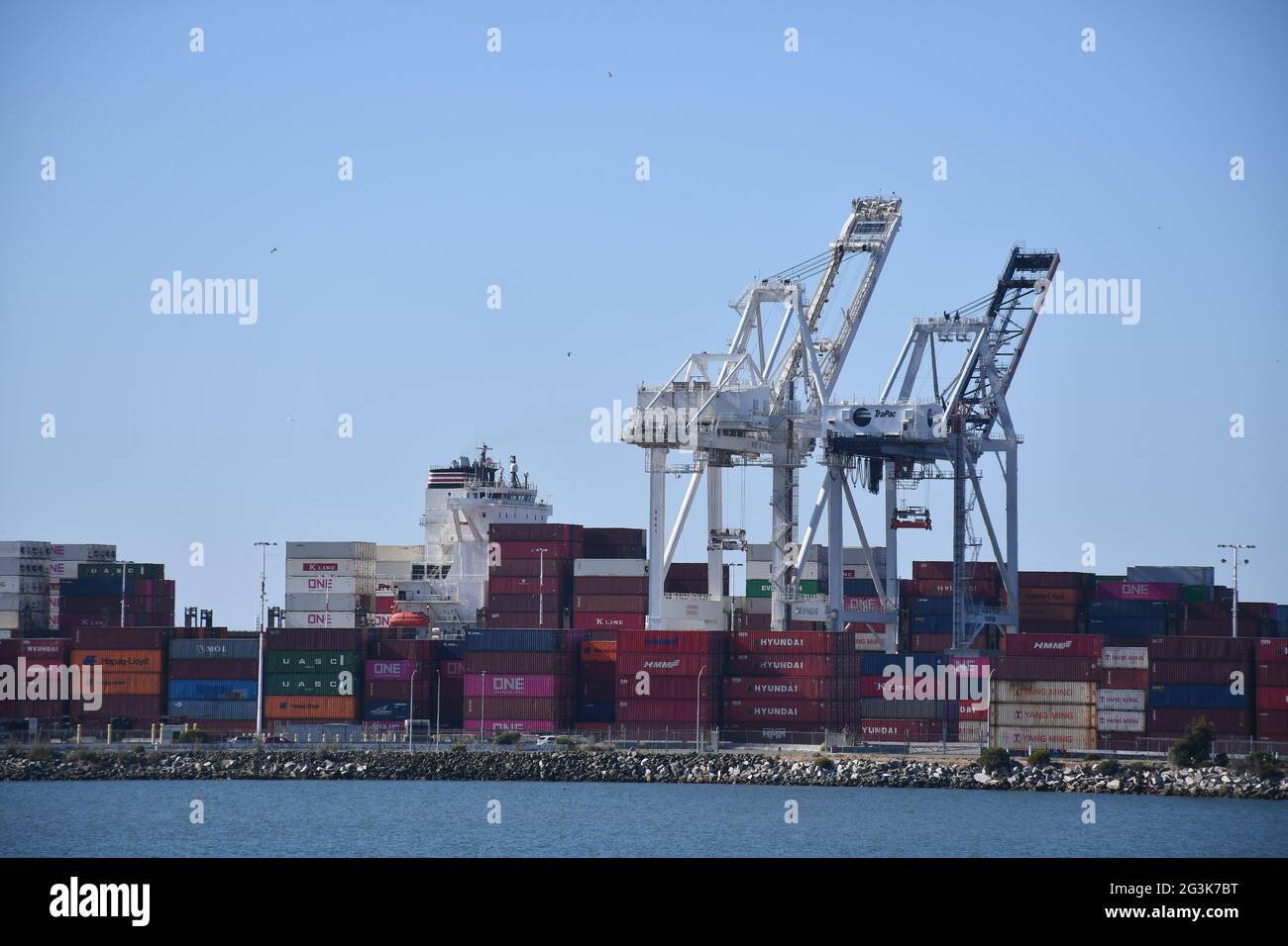I contenitori per la spedizione vengono caricati sulle navi del porto di Oakland, California, uno dei porti di trasporto più trafficati della costa occidentale. Foto Stock