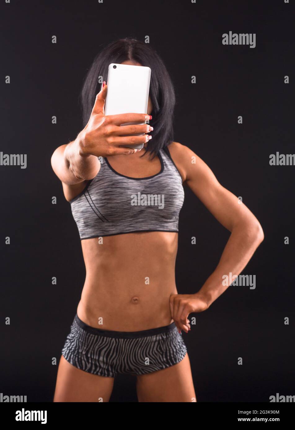 Donna Fitness rendendo self foto in studio Foto Stock