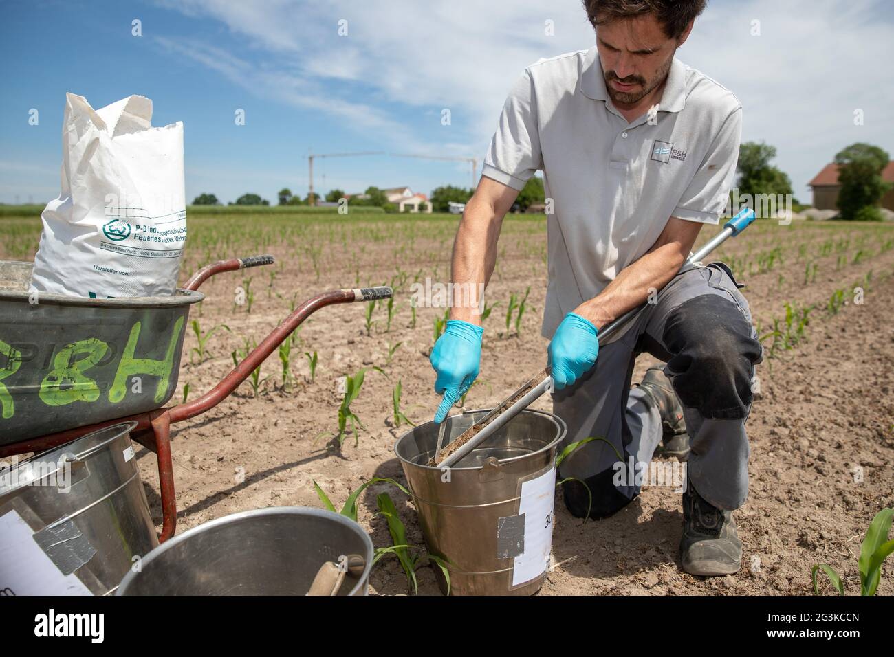 15 giugno 2021, Baviera, Katterbach: Alexander Seitz, tecnico di campionamento di un ufficio di ingegneria ambientale per l'indagine di siti contaminati, preleva campioni di terreno su un campo vicino alla base militare americana Katterbach. A causa di un'elevata concentrazione di sostanze chimiche per- e polifluorurate (PFAS) nel suolo e nelle acque sotterranee presso le caserme degli Stati Uniti, i campioni sono attualmente in corso di prelievo. Tali misure sono intese a fornire conclusioni sulla direzione del flusso delle acque sotterranee e sulla possibile entità della contaminazione da parte di sostanze chimiche - in precedenza abbreviate PFC - provenienti da vigili del fuoco Foto Stock