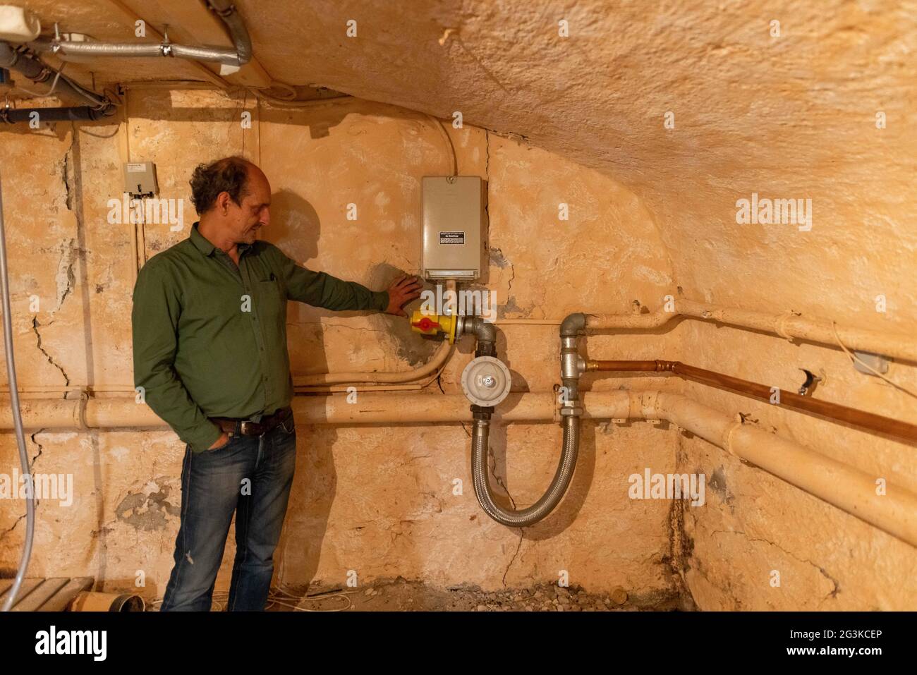 Staufen im Breisgau, Germania. 01 Giugno 2021. Clemens Oberle si trova accanto al raccordo del gas nella sua cantina a Staufen, che è regolarmente monitorato e è stato ricostruito più volte. La città di Breisgau ha lottato contro le crepe nel centro storico della città causate da un'imponente perforazione geotermica nel 2007. Nelle vicinanze del Graben Alto Reno, si può vedere in una piccola area ciò che l'energia geotermica può fare - e dove causa problemi. Credit: Philippe von Ditfurth/dpa/Alamy Live News Foto Stock