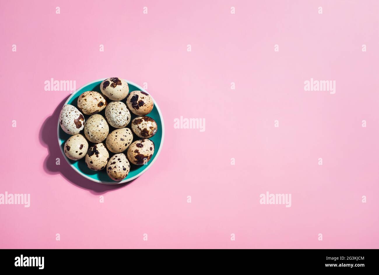 Posa piatta di un uovo di quaglia in un piatto verde su sfondo blu Foto Stock