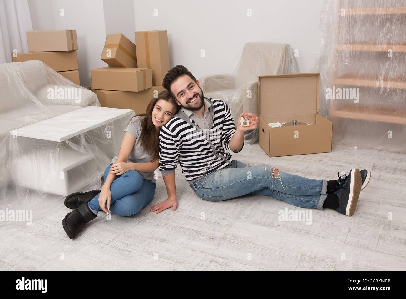 Uomo e donna sorridente preparando a trasferirsi in una nuova casa. Foto Stock