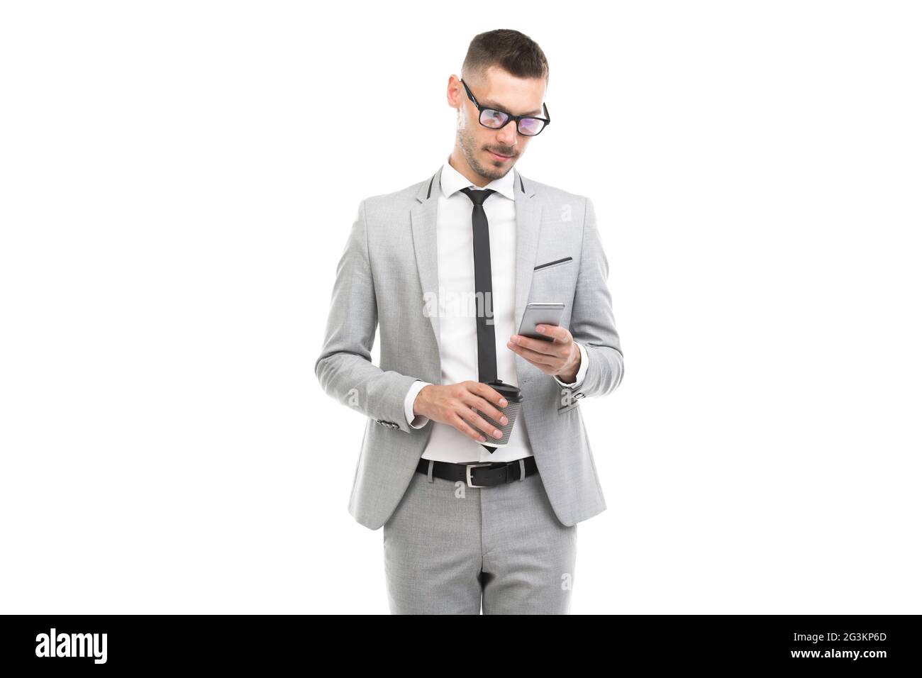 Ritratto orizzontale medio di bel giovane adulto caucasico uomo d'affari con vestito grigio e occhiali che tengono la tazza di caffè e smartphone Foto Stock