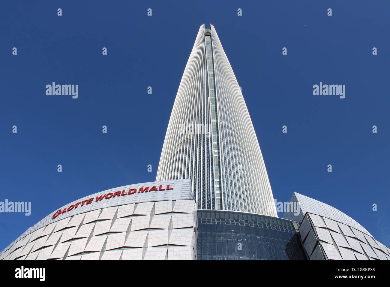 Vista base del centro commerciale Lotte World Mall e della Lotte Tower, contro il cielo blu chiaro Foto Stock