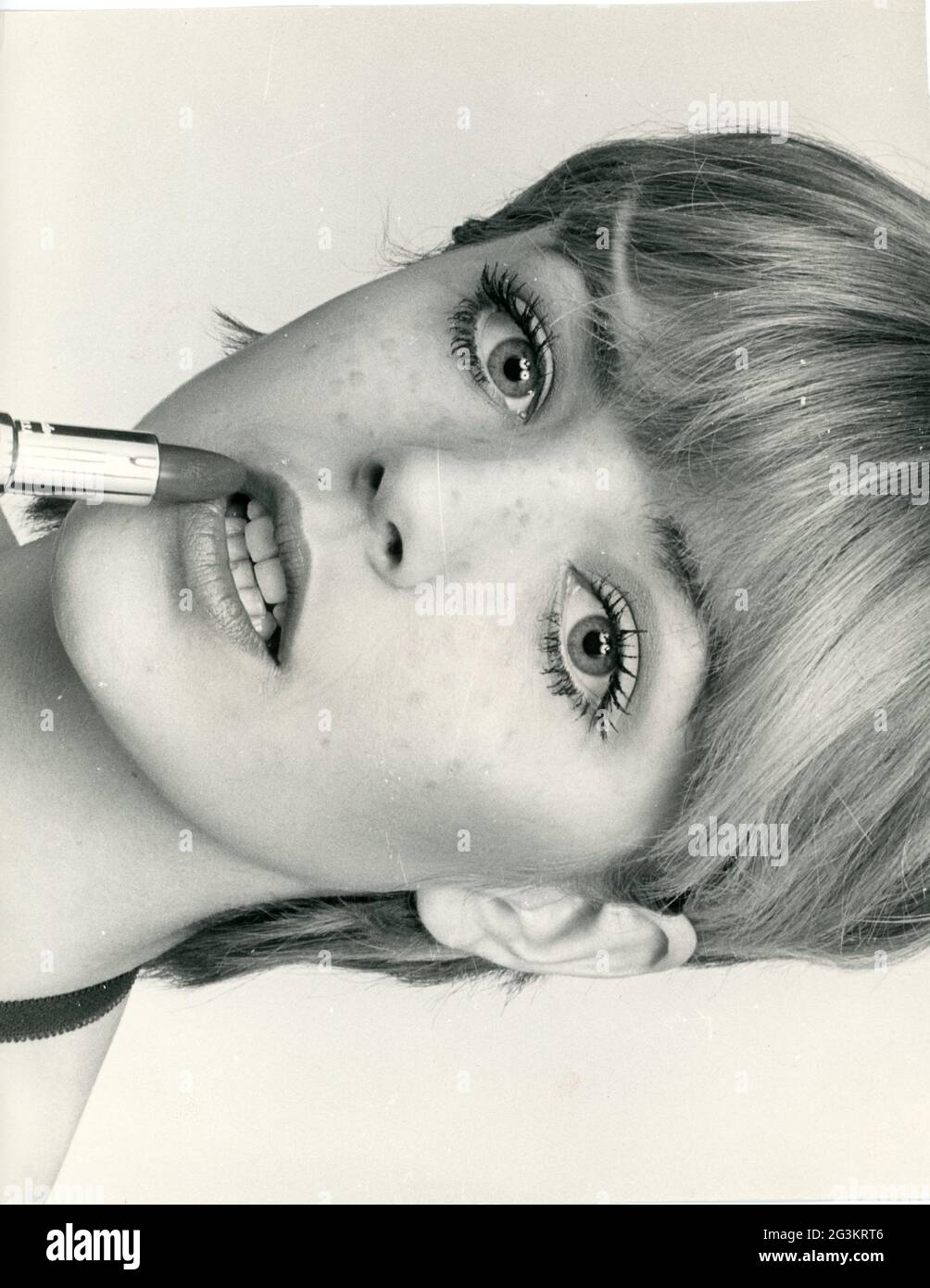 Cosmetici, giovane donna che applica rossetto, fine anni '60, DIRITTI-AGGIUNTIVI-CLEARANCE-INFO-NON-DISPONIBILE Foto Stock