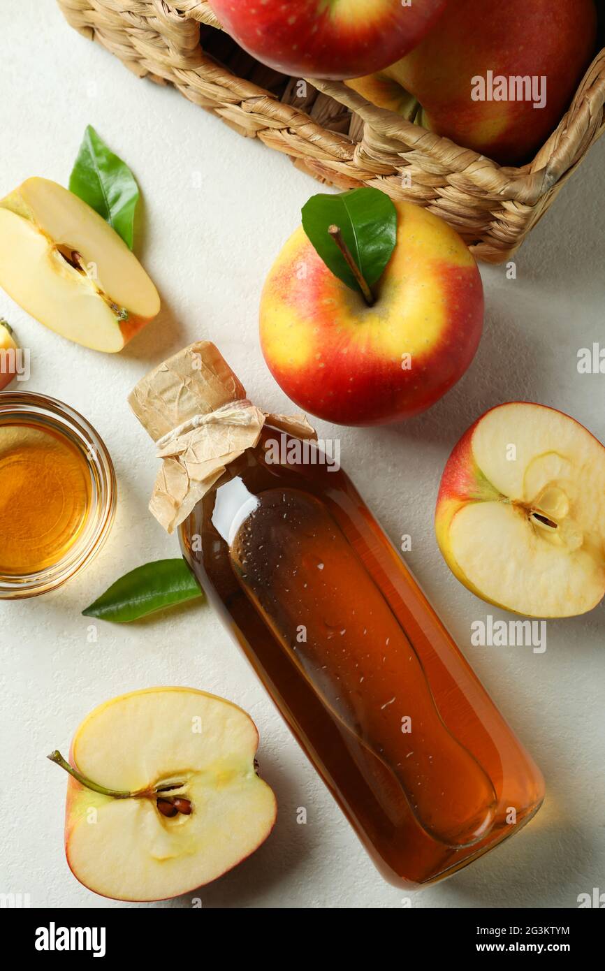 Aceto di mele fatto in casa e ingredienti su tavola bianca testurizzata Foto Stock