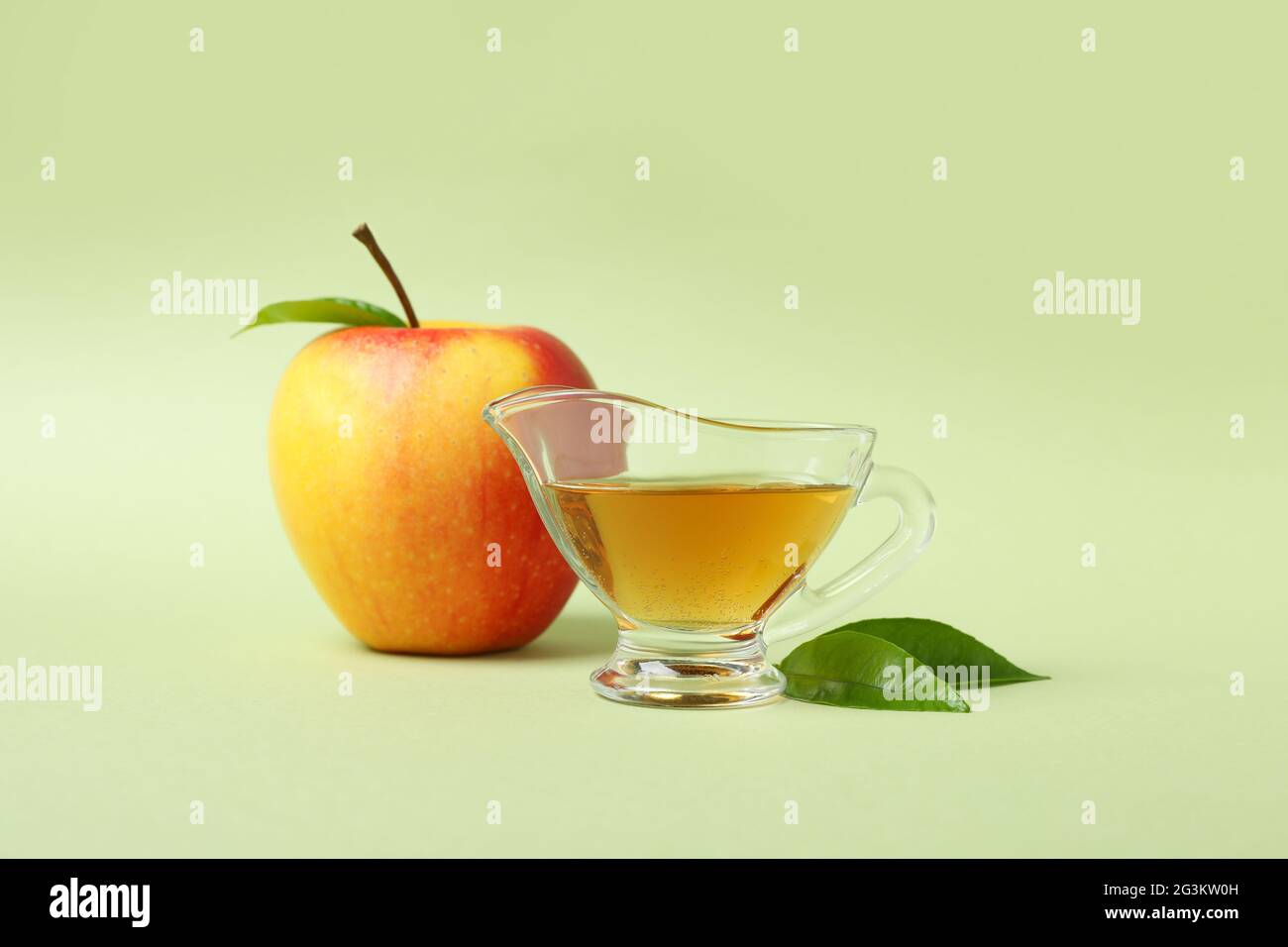 Aceto di mele fatto in casa e ingrediente su sfondo verde Foto Stock