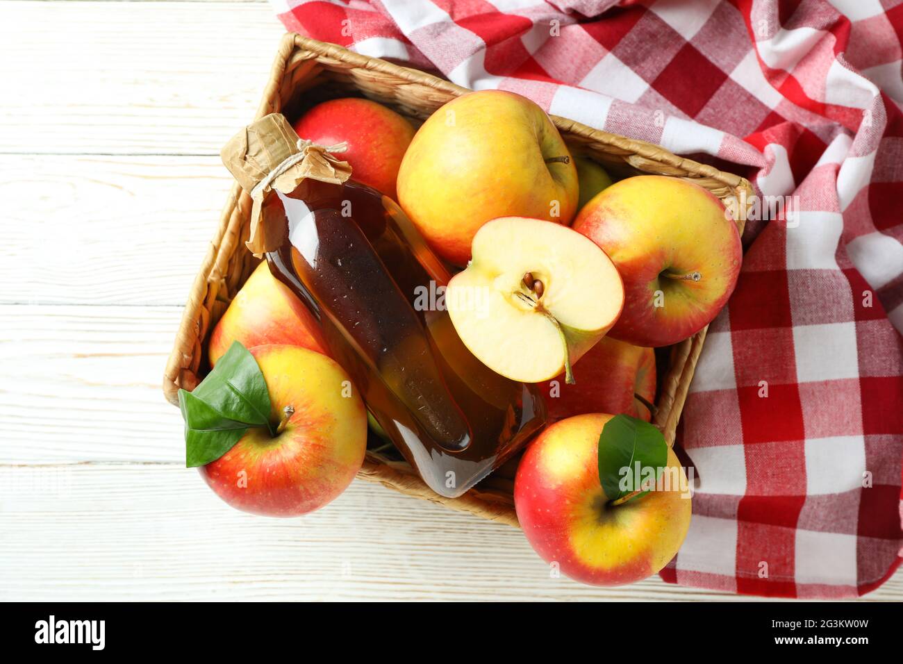 Aceto di mele fatto in casa e ingredienti su tavola di legno bianco Foto Stock
