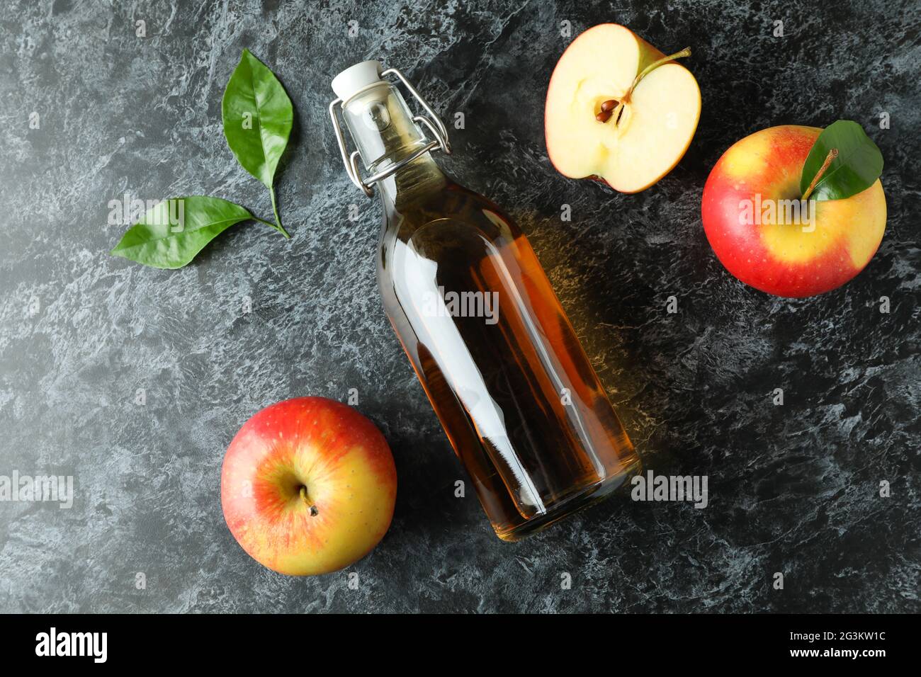 Aceto di mele fatto in casa e ingredienti su tavolo nero affumicato Foto Stock