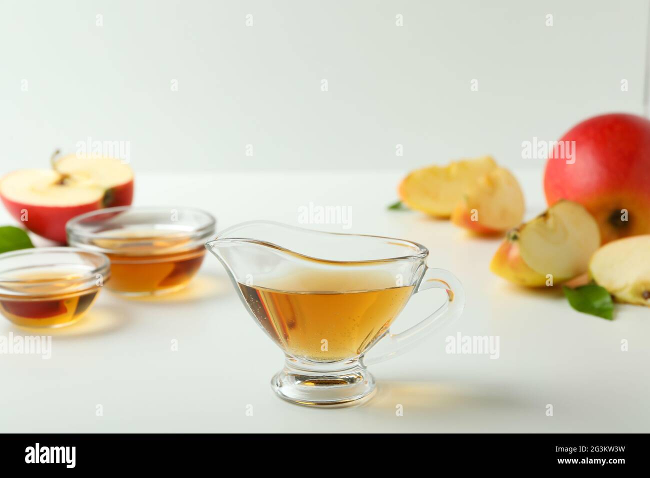 Aceto di mele fatto in casa e ingredienti su tavola bianca Foto Stock